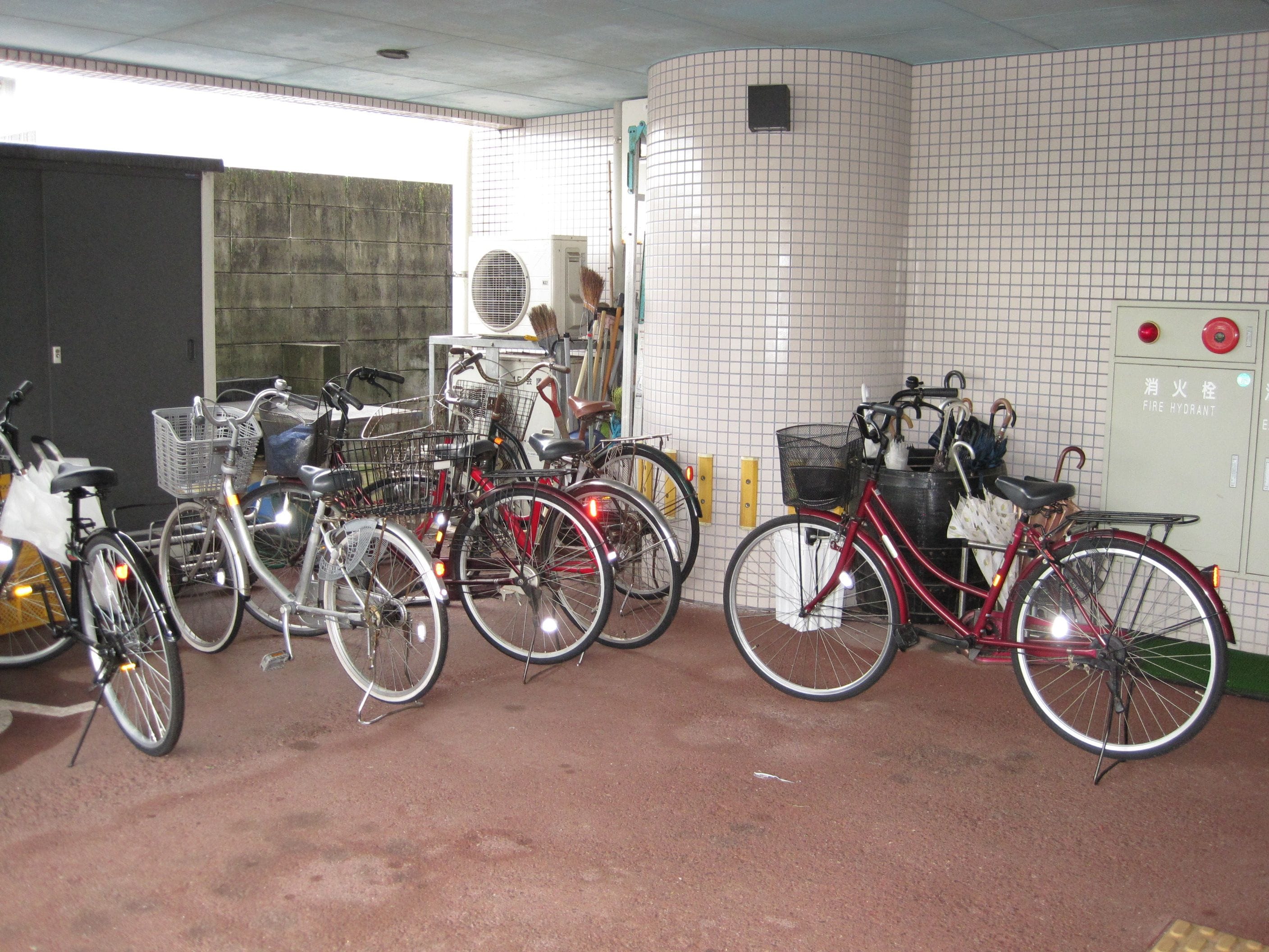 A bicycle parking area with multiple bicycles and a fire hydrant sign.