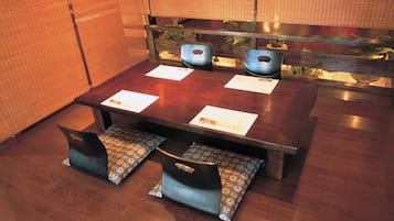 Una mesa de madera para comer con cuatro sillas, cada una con un cojín estampado.
