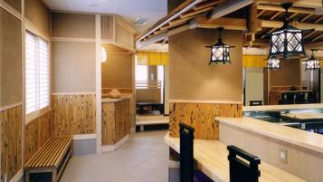 A restaurant interior with wooden paneling, a counter, and hanging lanterns.