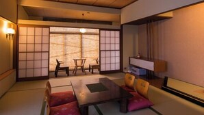 A traditional Japanese room with tatami flooring, a low table, cushions, and sliding doors. - Yado Atagoya (Fukushima)