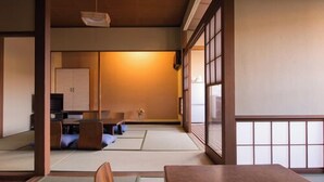 A traditional Japanese room with tatami flooring, a low wooden table, and a cushioned bench. - Yado Atagoya (Fukushima)