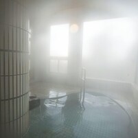 Un baño de vapor con suelo de baldosas y barandilla de metal.