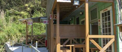 A wooden cabin with multiple rooms labeled M1, M2, M3, and M4, each with a small porch and a window.