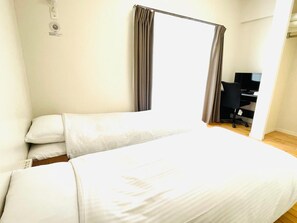 Una habitación de hotel con una cama, un escritorio y una silla.
