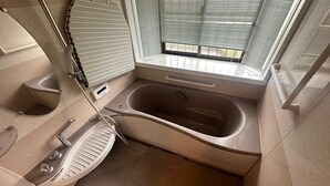 Une salle de bain moderne avec une baignoire sur pieds, des toilettes et un bidet.