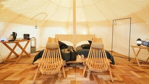 A cozy tent with two wooden chairs, a bed, a table with a kettle, and a lamp. - Rita's Ranch Minami Karuizawa (Karuizawa)