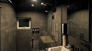 A modern bathroom with a large mirror, a shower with overhead lights, and a sink with a faucet. - Rita's Ranch Minami Karuizawa (Karuizawa)