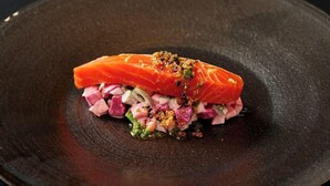 A salmon dish with diced vegetables and herbs on a dark plate. - Rita's Ranch Minami Karuizawa (Karuizawa)