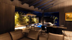 A modern indoor space with a pool, leather seating, and a dining area. - The Goat Awaji (Awaji)