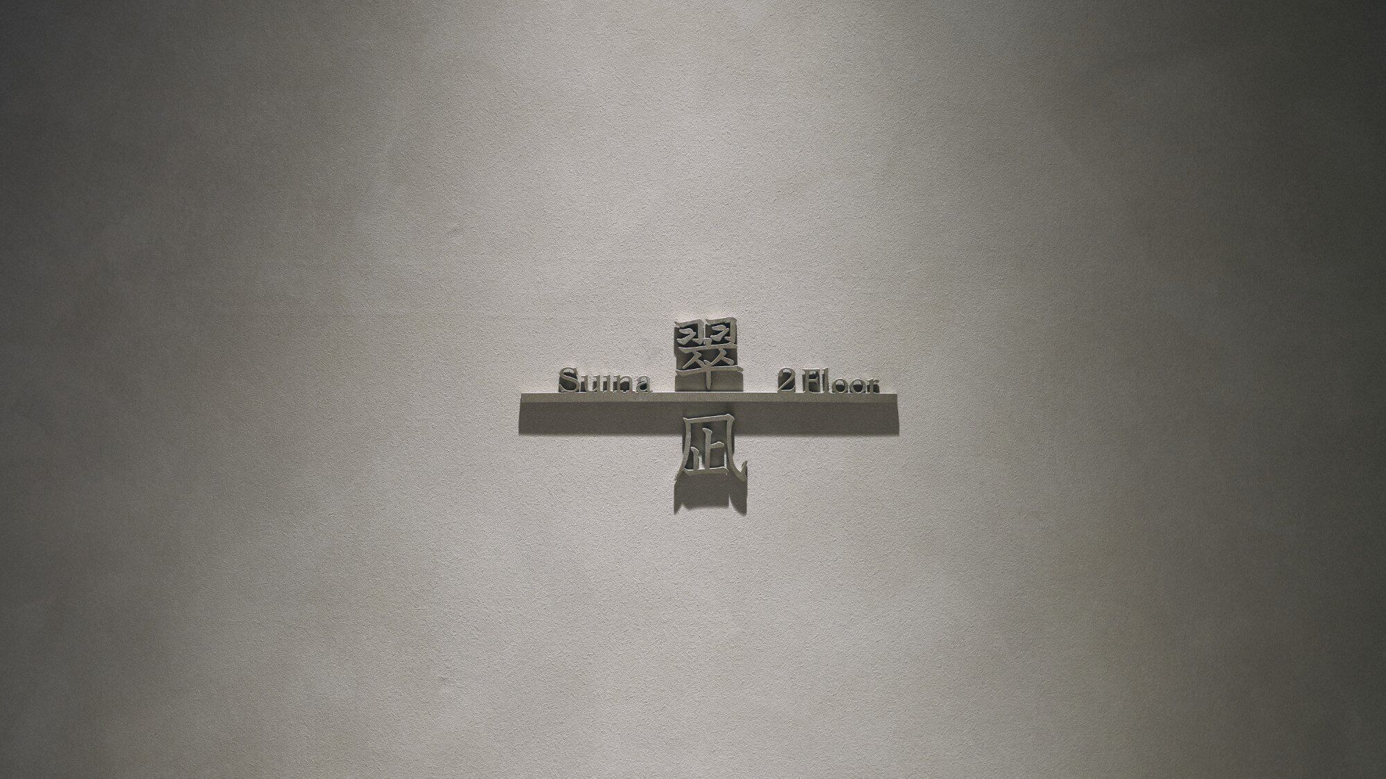 Una pared con un estante que exhibe un letrero con texto coreano.