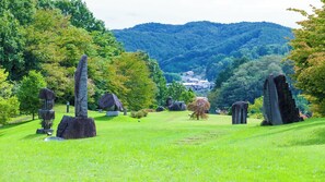 A cemetery with various stone monuments and a distant view of a village. - Mobilita Court Iwate (Iwate)
