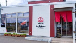 A building with a red and white facade, a large window displaying a meat advertisement, and a red awning with the FUGANE logo. - Mobilita Court Iwate (Iwate)