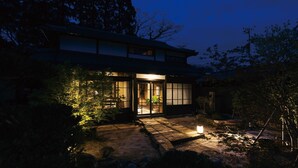 A traditional Japanese house with a wooden exterior, large sliding doors, and a stone pathway leading to the entrance. - Paak Hotel (Nichinan)