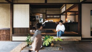 A traditional Japanese interior with tatami flooring, a low wooden table, and a seating area with cushions. - Paak Hotel (Nichinan)