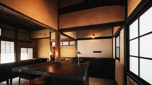 A traditional Japanese-style room with tatami flooring, a low wooden table, and sliding doors. - Paak Hotel (Nichinan)