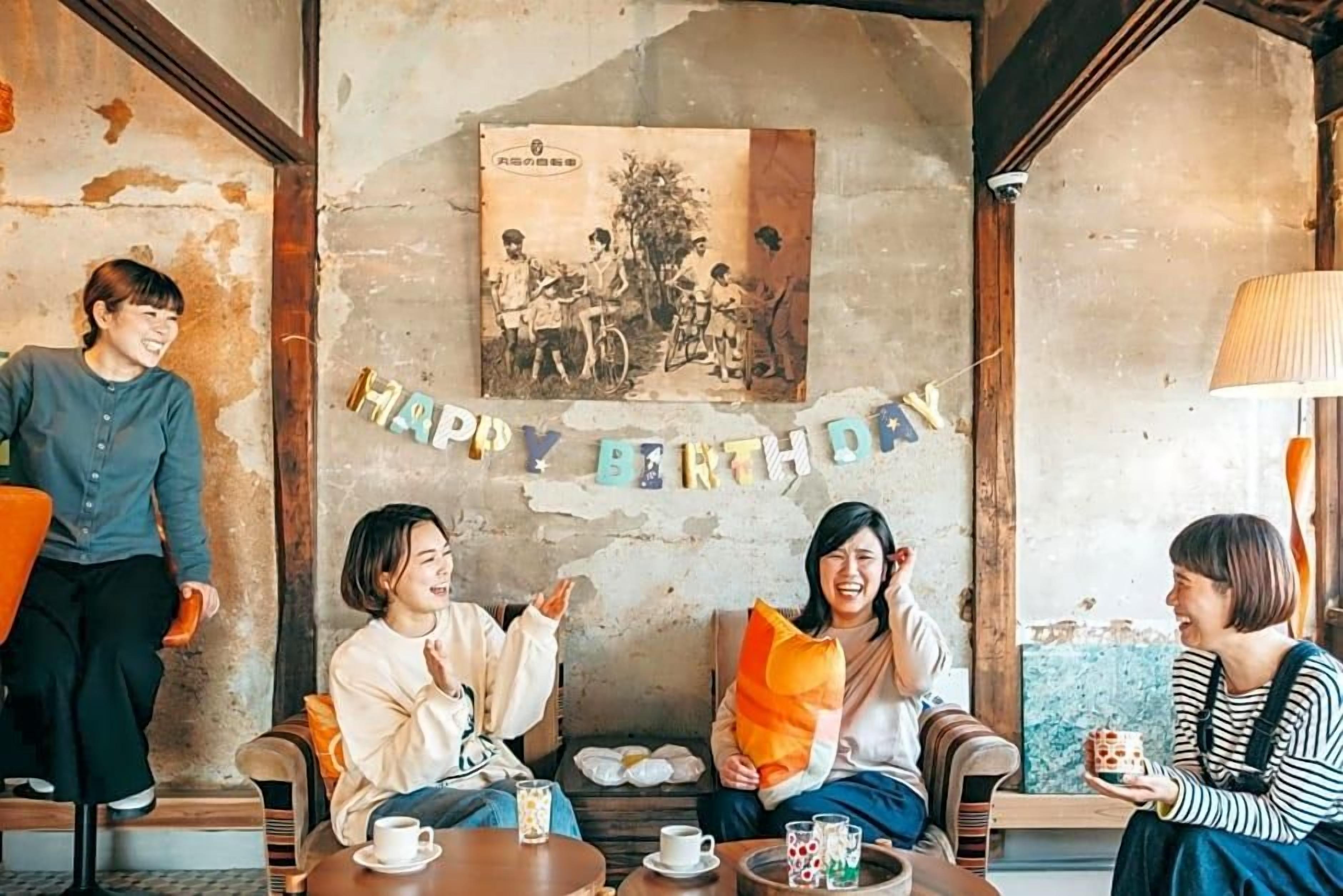 A cozy indoor setting with a rustic wall, a birthday banner, and a vintage photo.