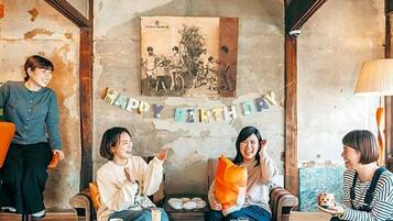 A cozy indoor setting with a rustic wall, a birthday banner, and a vintage photo.
