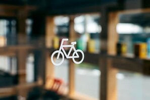 A blurred interior view of a building with a bicycle symbol on a window. - Yado Charinko (Gose)