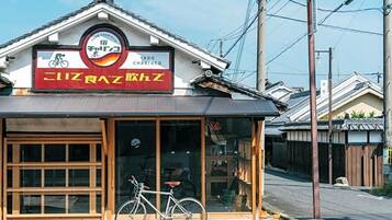 A small building with a signboard and a bicycle parked in front.