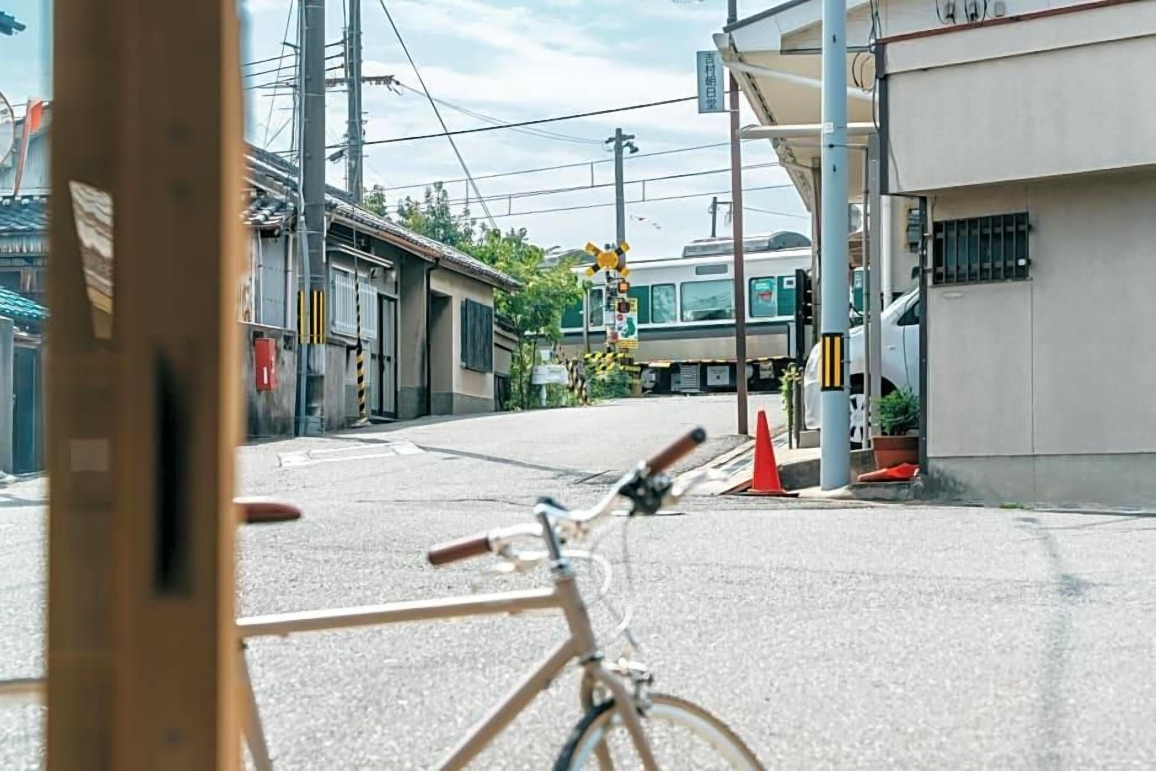 A bicycle parked on a street with a train in the background.
