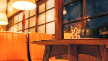 A round wooden table with a glass and a candle.
