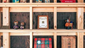 A wooden shelf with various items including books, figurines, and framed certificates.