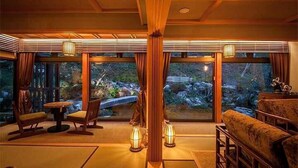 A room with a view of a rocky landscape through large windows, a wooden ceiling, and traditional Japanese furnishings. - Tokisumika (Komagane)