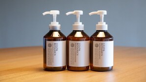 Drie flessen Leaf & Botanics Refresh Conditioner op een houten ondergrond.