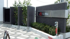 A modern hotel entrance with a checkered floor, a signboard, and a water fountain. - Hotel Nishiyama (Minamisoma)