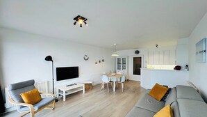 Moderni olohuone, jossa on sohva, nojatuoli ja ruokapöytä.