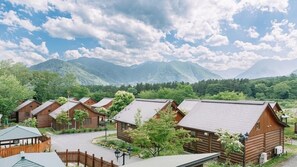 A row of log cabins with a mountain backdrop. - Canadian Village Montreal (Omachi)