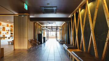 A hallway with wooden paneling, benches, and a bookshelf.