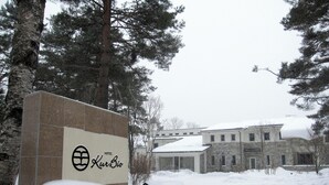 A hotel sign with a stone facade and a snow-covered landscape. - Kusatsu Onsen Hotel Kurbio (Kusatsu)