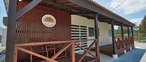 Un espacio de estar al aire libre cubierto con muebles de madera y un letrero.