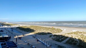 A beachside hotel with a parking area, beach access, and dune vegetation. - Sea-view apartment on Zeedijk (NIEUWPOORT)