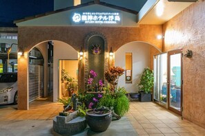 A hotel entrance with a sign, arched doorways, and potted plants. - Kariyushi Condominium Resort Naha Ryujin Hotel Ukishima (Naha)