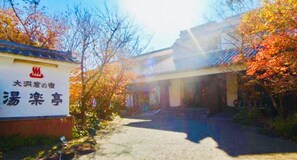 A traditional Japanese building with a signboard, surrounded by autumn foliage. - Yurakutei (Kamiamakusa)