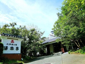 A traditional Japanese building with a tiled roof and a signboard in front. - Yurakutei (Kamiamakusa)