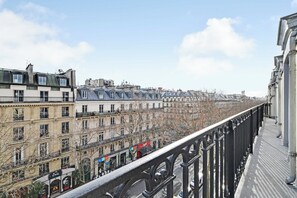 Une rangée de bâtiments dotés de balcons, un ciel dégagé et un pont en arrière-plan.
