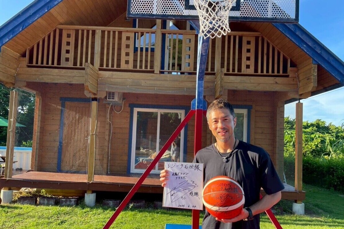 Un terrain de basket avec une structure en bois en arrière-plan.