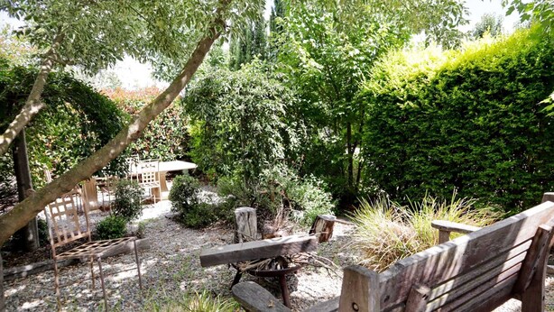A rustic outdoor seating area with wooden benches and a rustic fire pit. - Spacious 4-Bed Home in Central Tenterfield (Tenterfield)