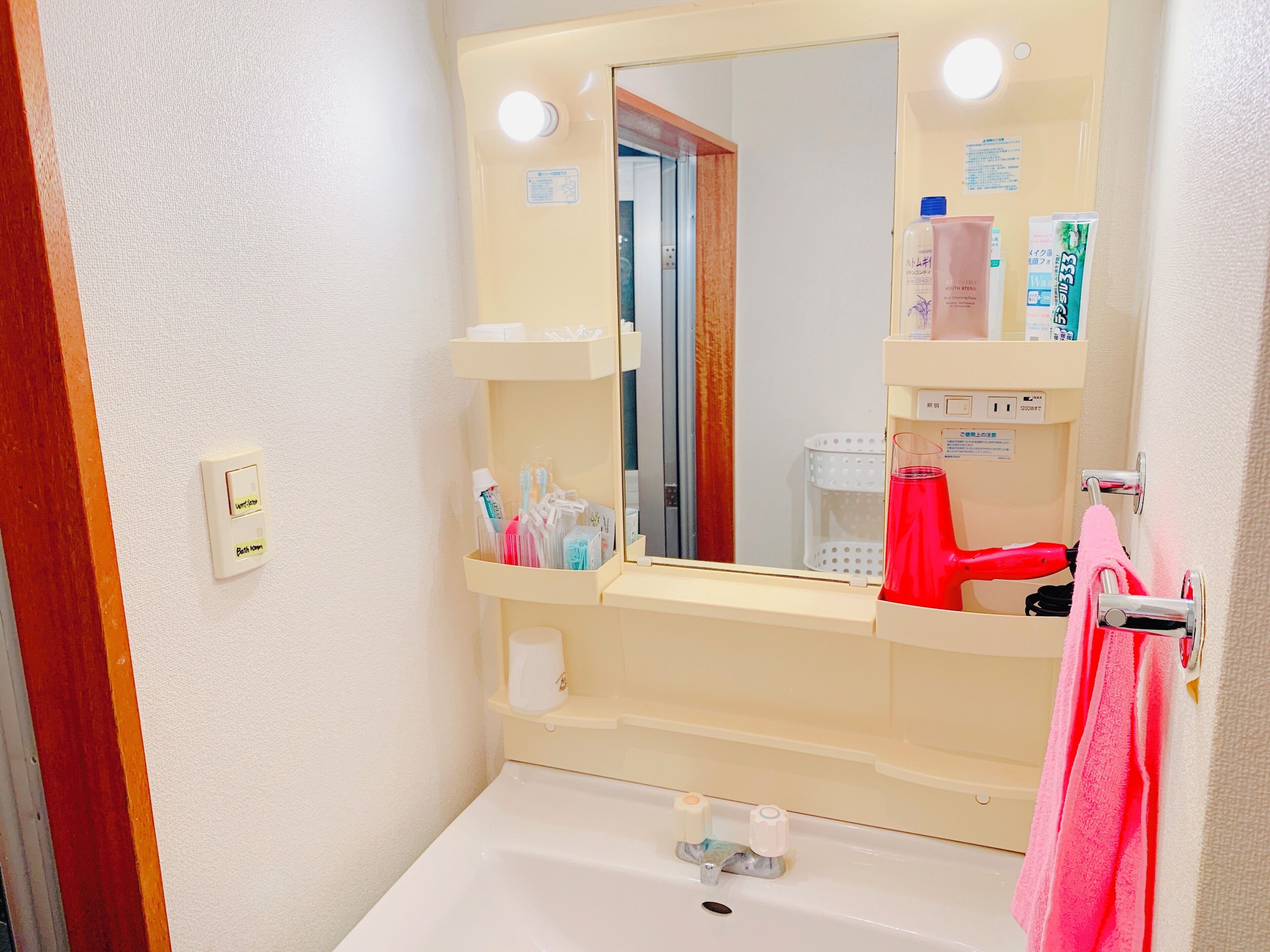 A bathroom with a sink, mirror, and various toiletries.