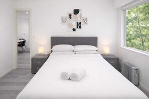 Escritorio, tabla de planchar con plancha, internet y ropa de cama