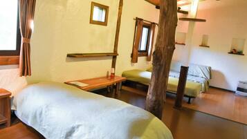 Una habitación acogedora con una cama, una mesita y un ventanal.