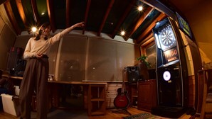 A room with a dartboard, a guitar, and a wooden ceiling. - Pension Xaymaca (Hara)
