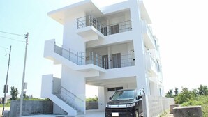 Un edificio moderno a più piani con un'auto parcheggiata davanti.