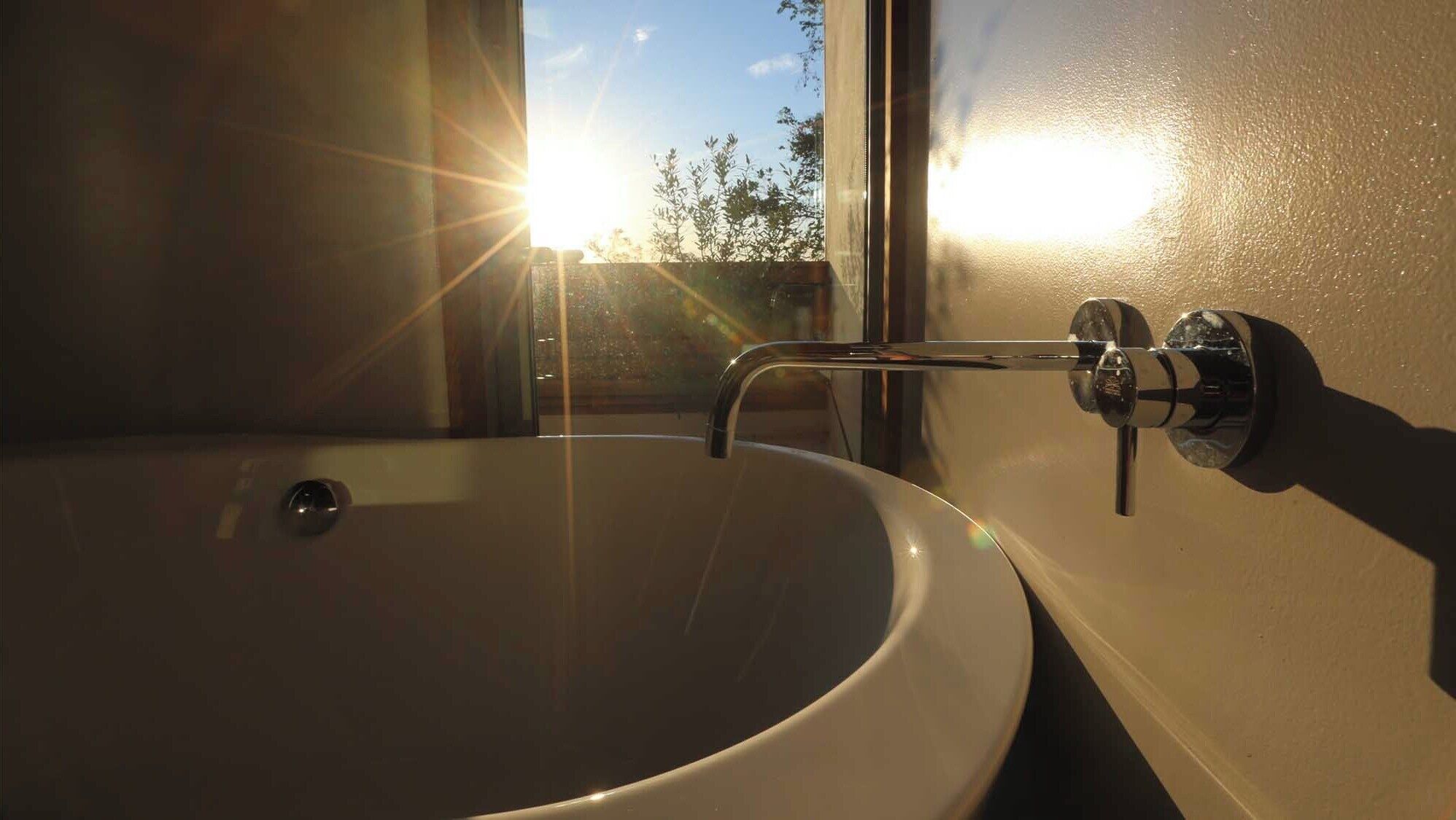 Une salle de bain avec un grand lavabo et un robinet.