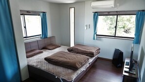 Une chambre à coucher avec un lit, un bureau et un ordinateur.