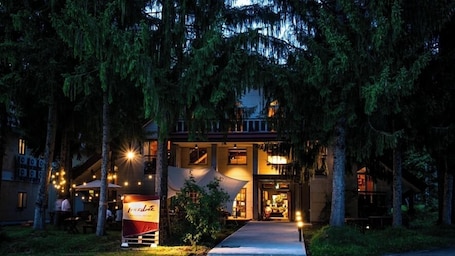 A two-story building with a covered outdoor seating area and a visible restaurant sign.