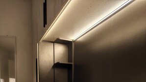 Ein modernes Schlafzimmer mit einem Bett, einem Nachttisch und einer Einbauschränken.